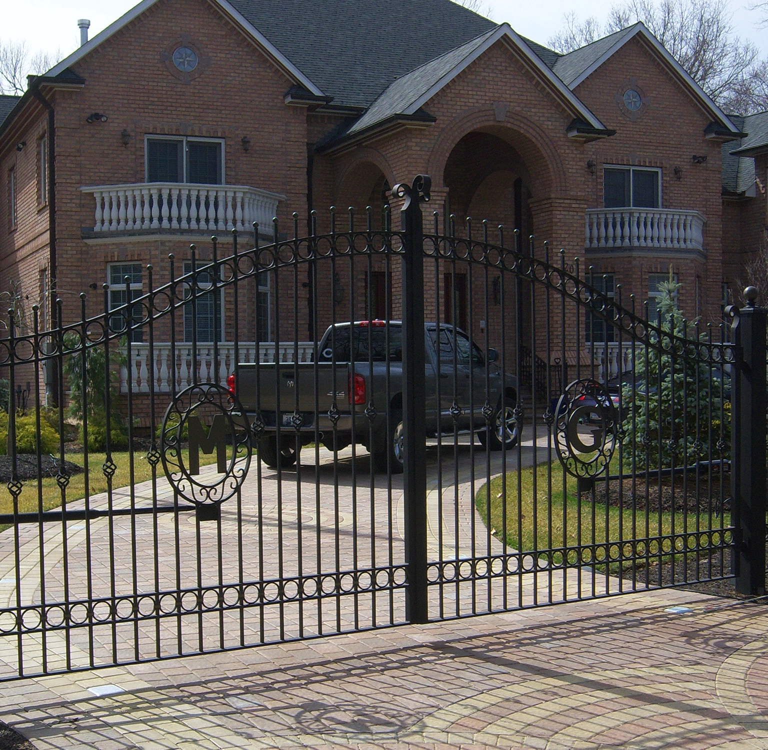 Outdoor Driveway Gate Monogrammed M and G Centered on Black Iron Wrought Gate